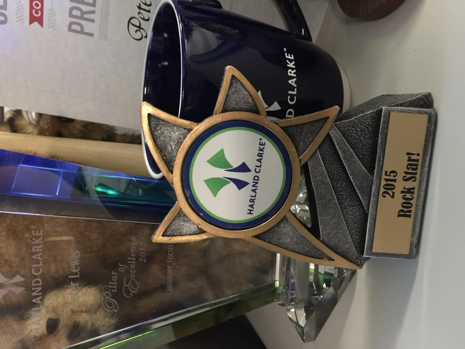 Harland Clarke awards on my desk: Pillar of Excellence 2012 for customer focus, and 2015 Rock Star
